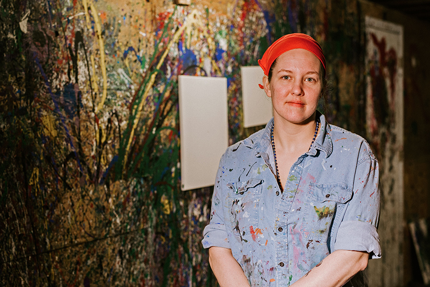 Heather Tarolli standing in front of a splat-painted wall